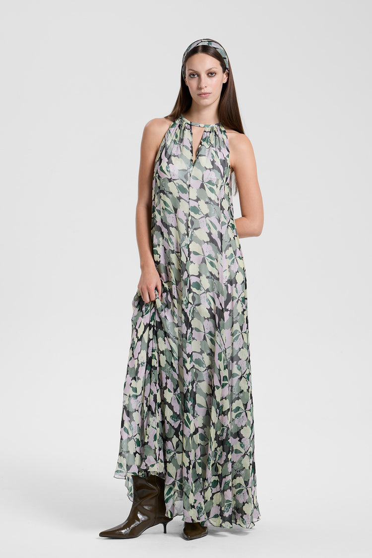Woman wearing a long, patterned dress on a white background